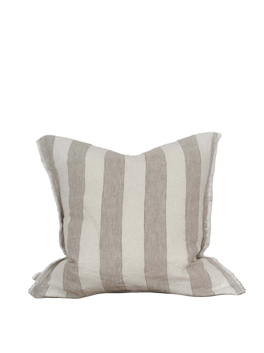 Striped pillow on a wooden surface with a white background